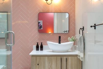 Feature herringbone wall with sink and vanity of the pink bathroom by Olivehaus Interiors