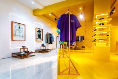 white space transitioning to the gold/yellow room of room xix - a modern fashion store by dhk designs.