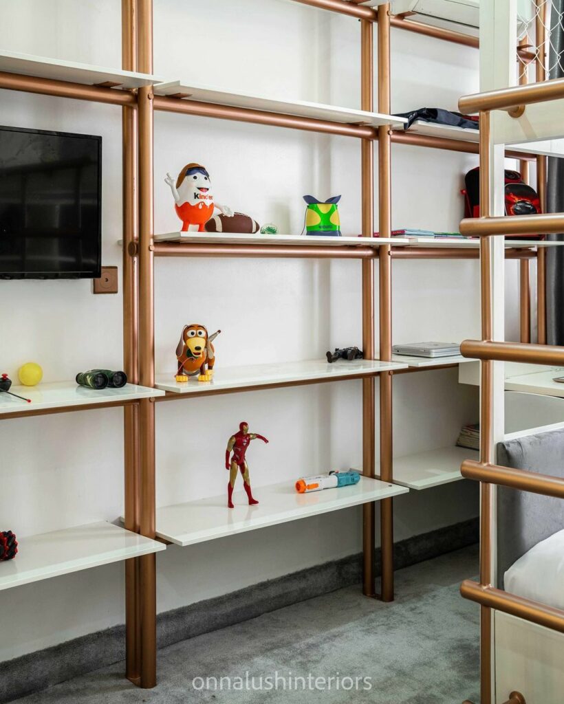 Wall-to-wall shelving unit in boy's bedroom by Onnalush Interiors