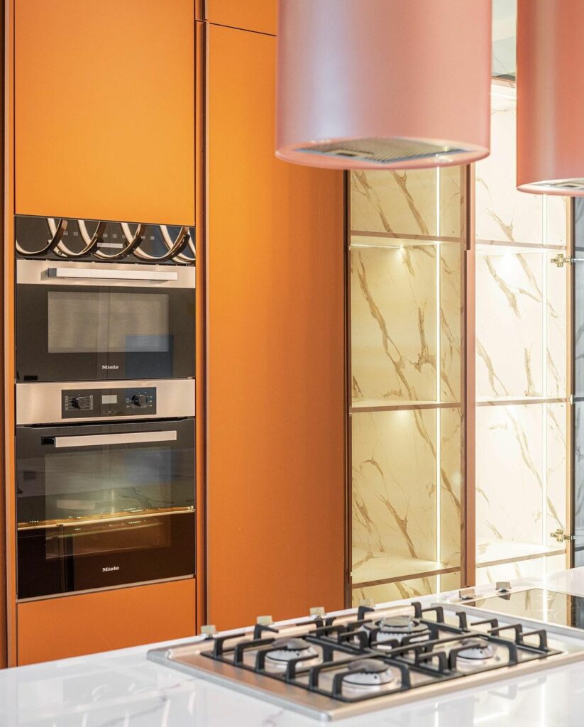 Burnt orange cabinets in the modern kitchen design by Rome Signature.