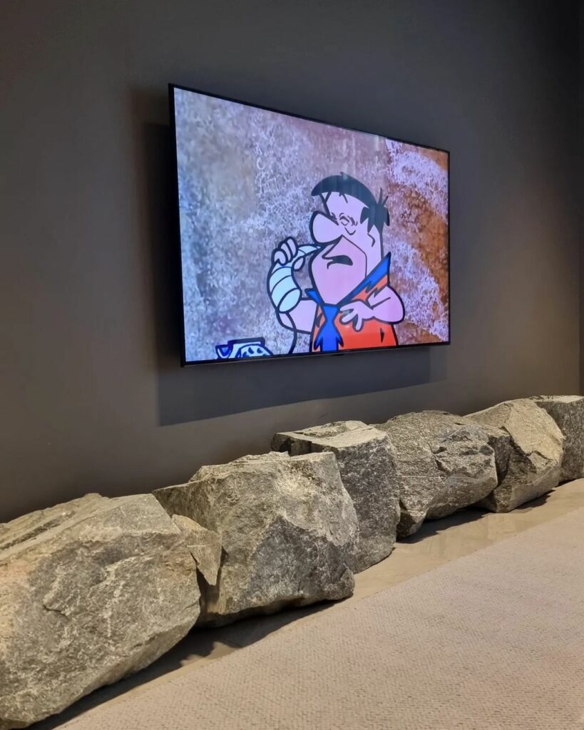 Boulders simulating tv console in Rock-themed living room design by Def Hills Interiors