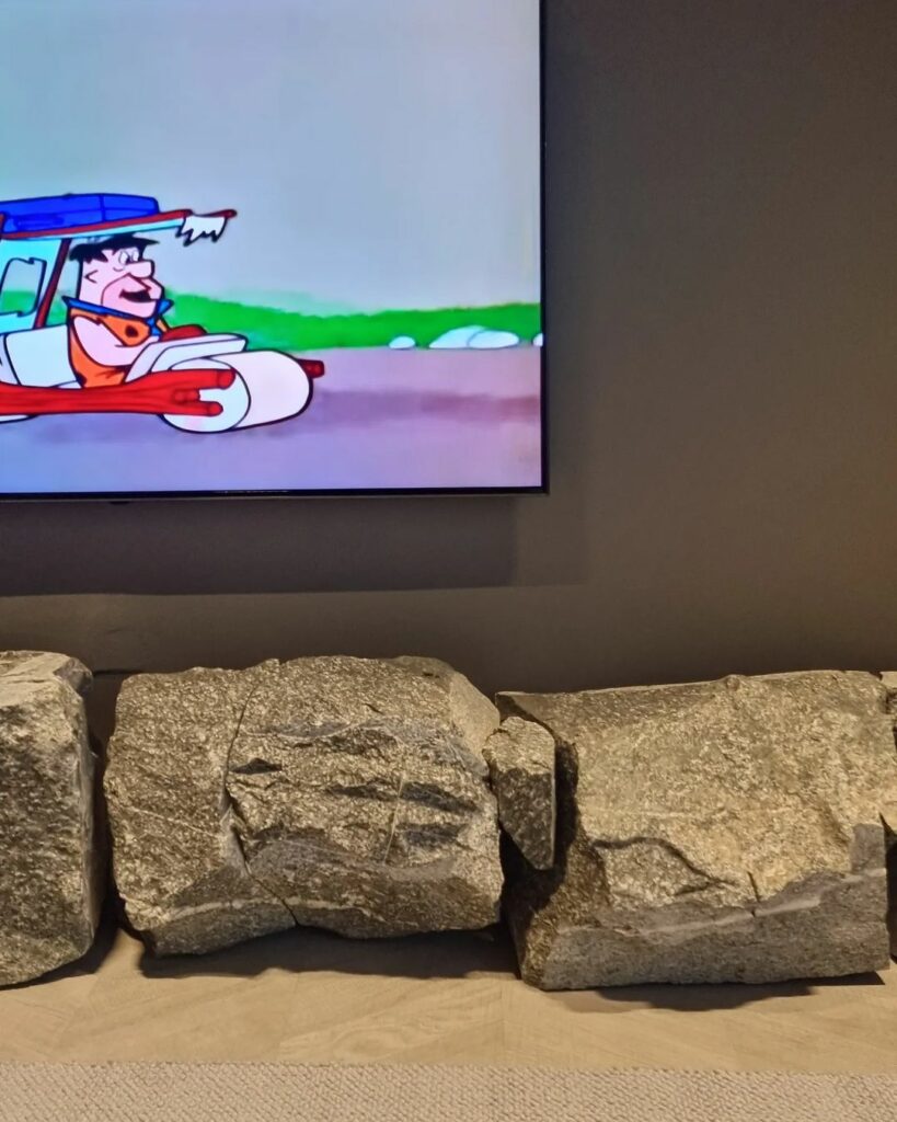 Boulders simulating tv console in Rock-themed living room design by Def Hills Interiors