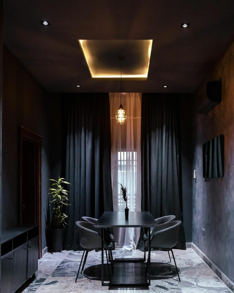 Dining area in Dark-Themed Contemporary Home in Abuja By dhk Designs lights on