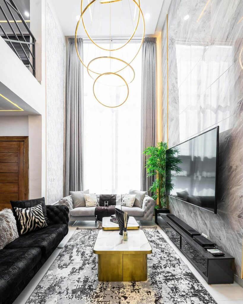 Double-volume Living Room with gold accents by Mimz Interiors