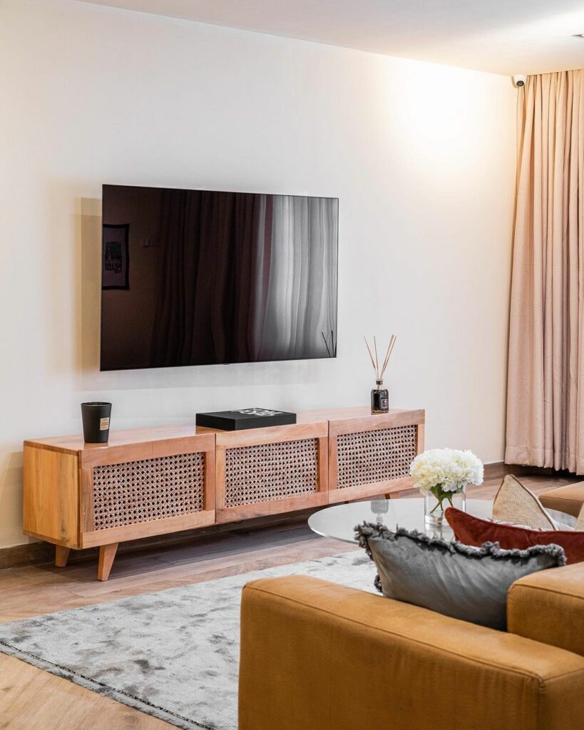 Rattan TV console in Rustic Minimalist Living Room Design By BrandBoy Studios