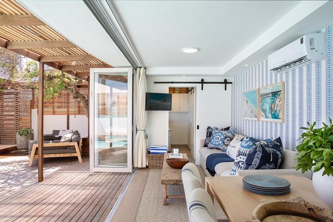 Living Area of a seaside apartment opening up to outdoor deck