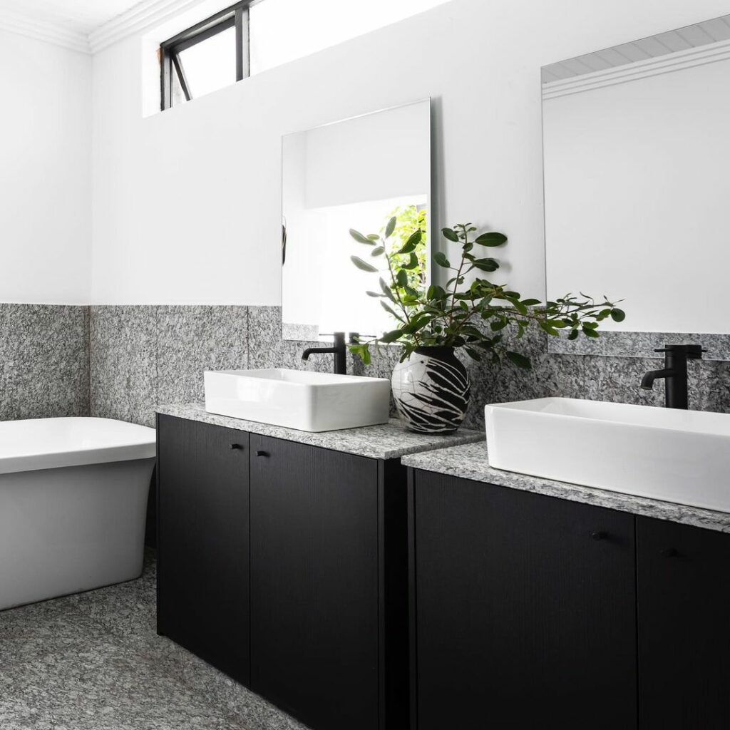 Modern bathroom with dark cabinetry and granite counters