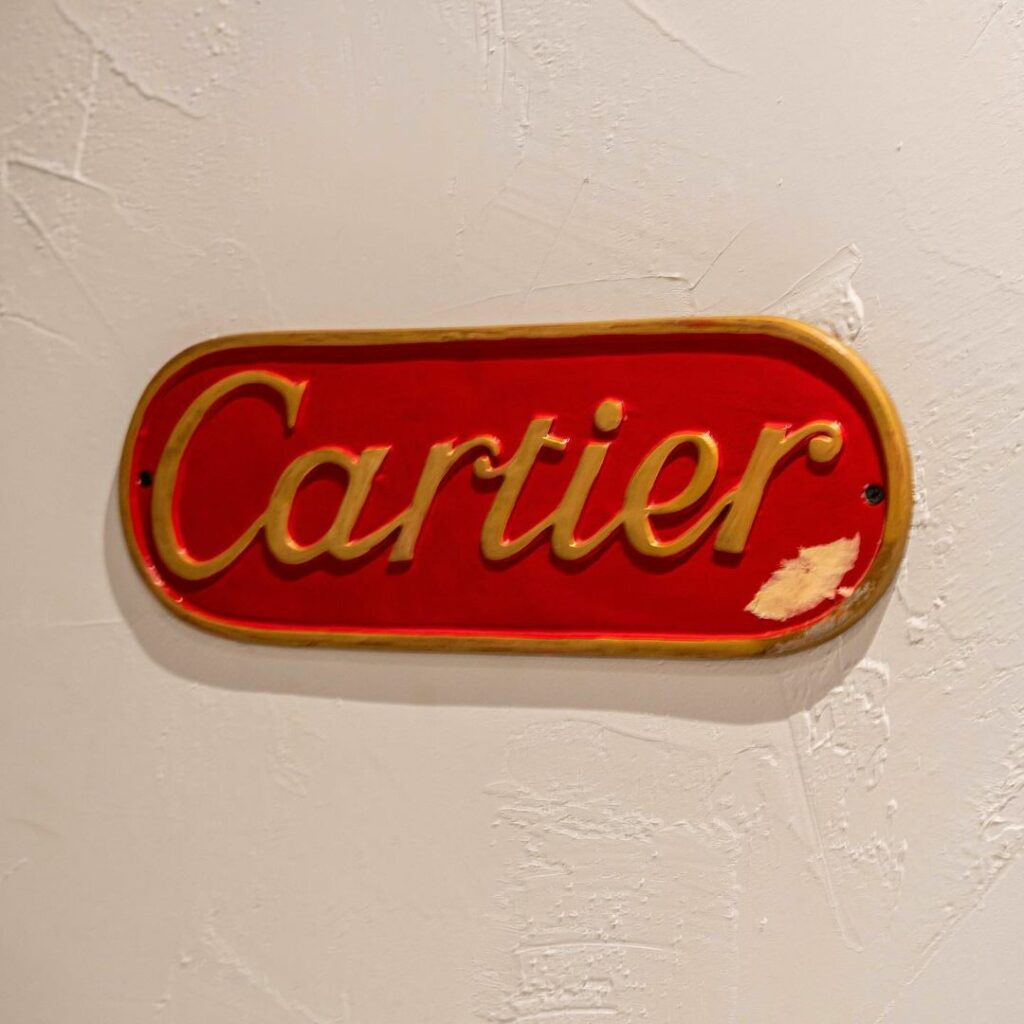 Pill-shaped sign on the wall that says: Cartier