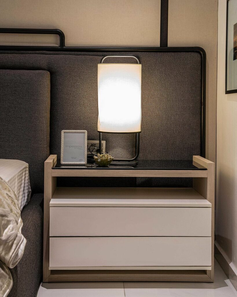 Desk lamp on a wide nightstand that has a
glass top