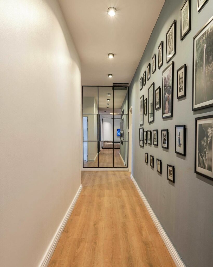 Hallway adorned with featuring a gallery wall and a mirror wall.