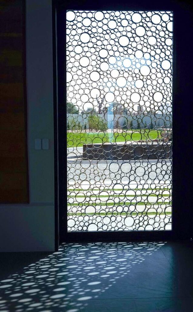 Perforated screen wall causing an interplay of shadows.