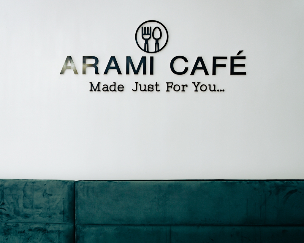Arami Cafe wall branding with tagline.