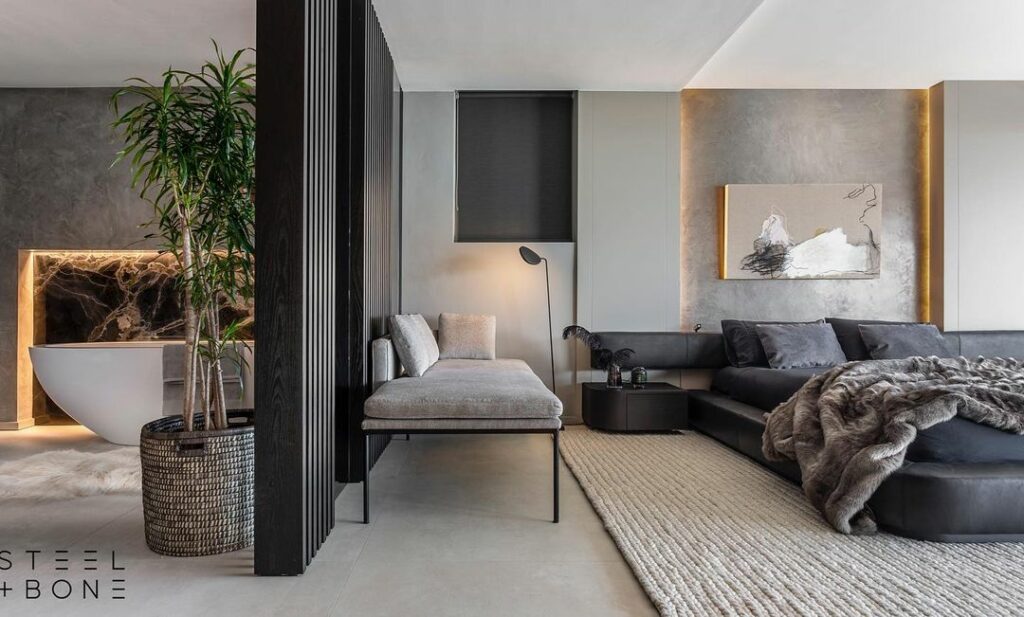 Luxurious interior design project by Steel and Bone in South Africa showing the cosy bedroom and a view of the bathroom.