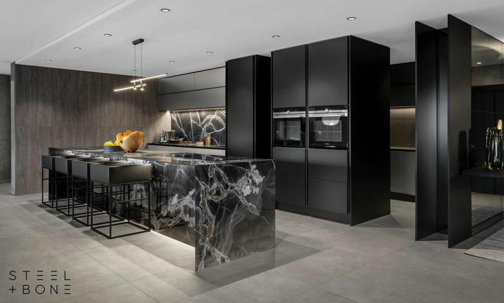 A view of the dark-themed kitchen in the luxurious interior by steel and bone.