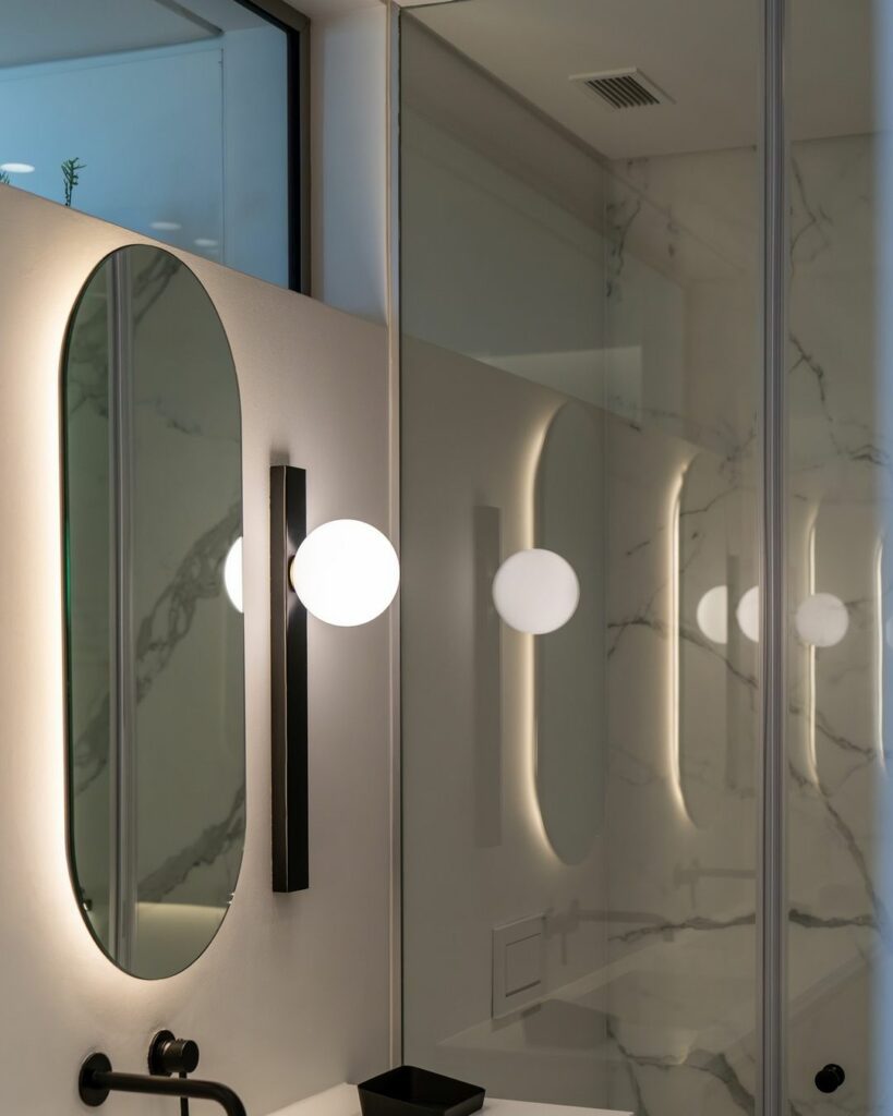 Capsule shaped mirror in a bathroom.