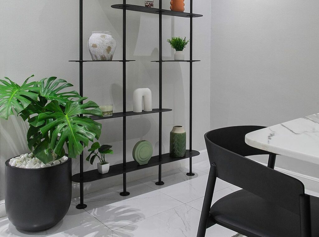 Black steel shelf in a dining area with black nordic-style seats.