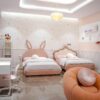 GIrls' bedroom in Lagos by Greyson Living. View showing feather pendant light and bubble sofas.