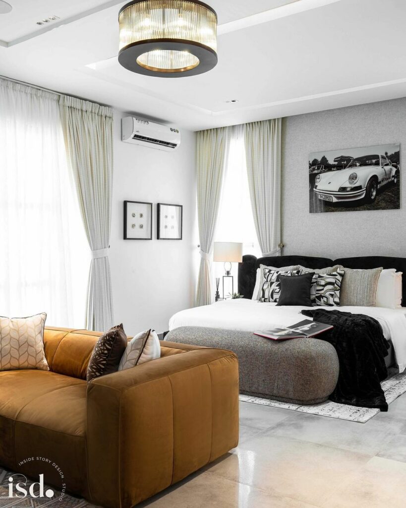 Contemporary bedroom design by ISD Studios with a view of the comfy mustard yellow sofa for entertainment.