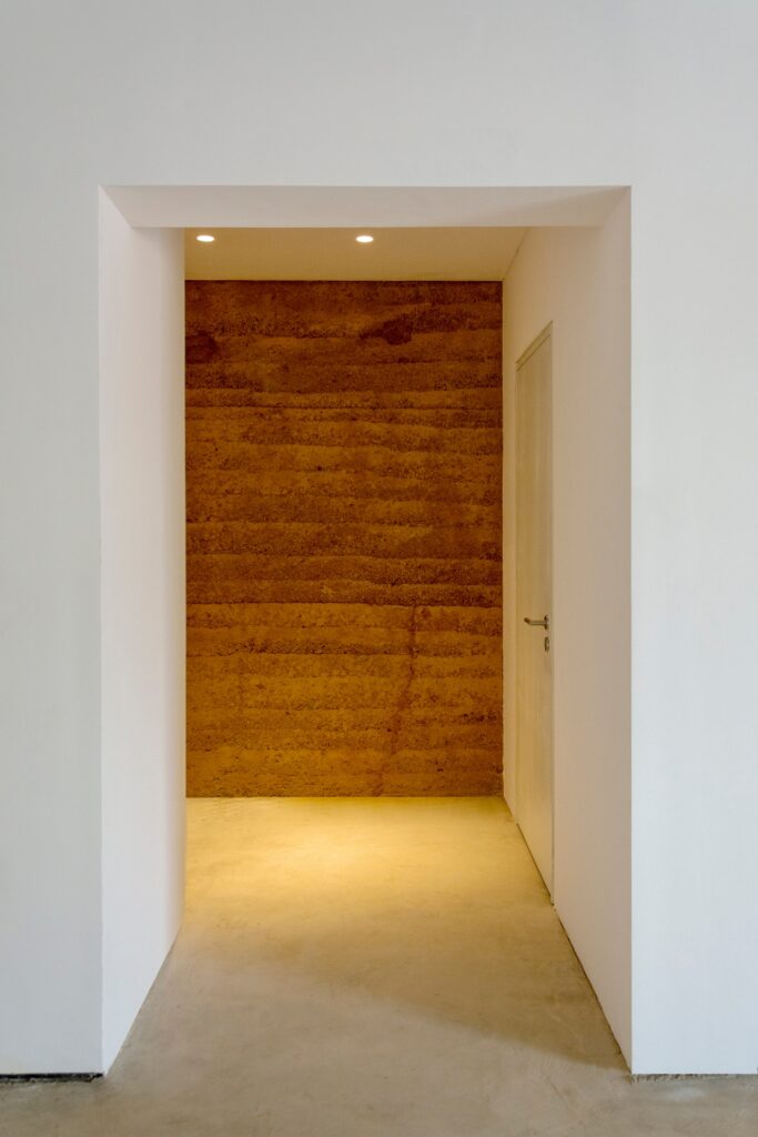 Featured rammed earth wall in interior of DOT Ateliers.