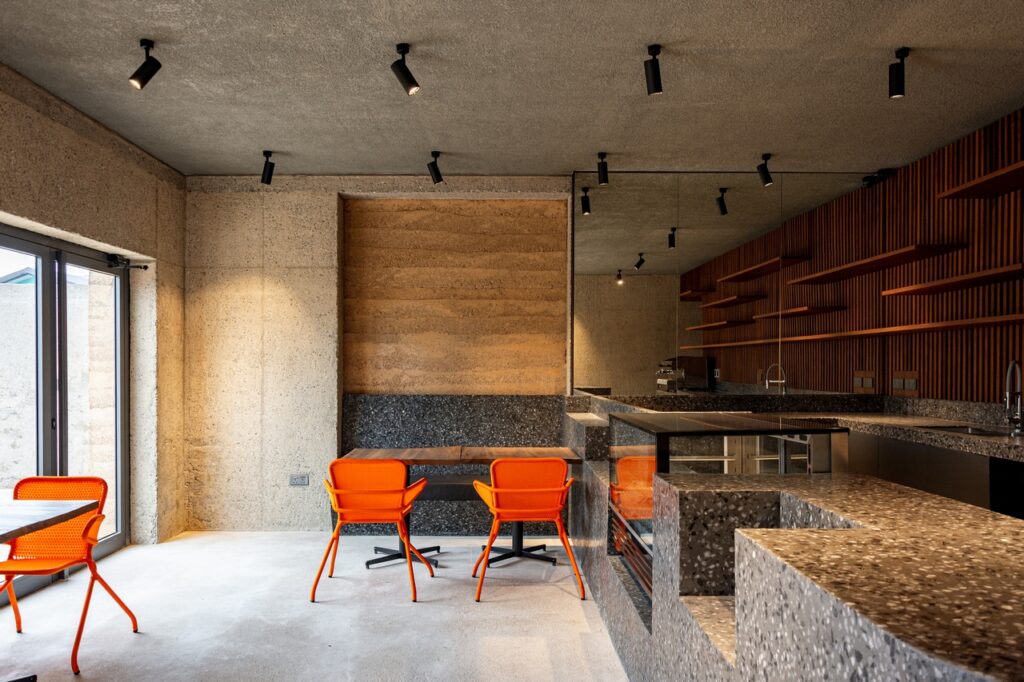 Rustic cafe interior with orange seats.
