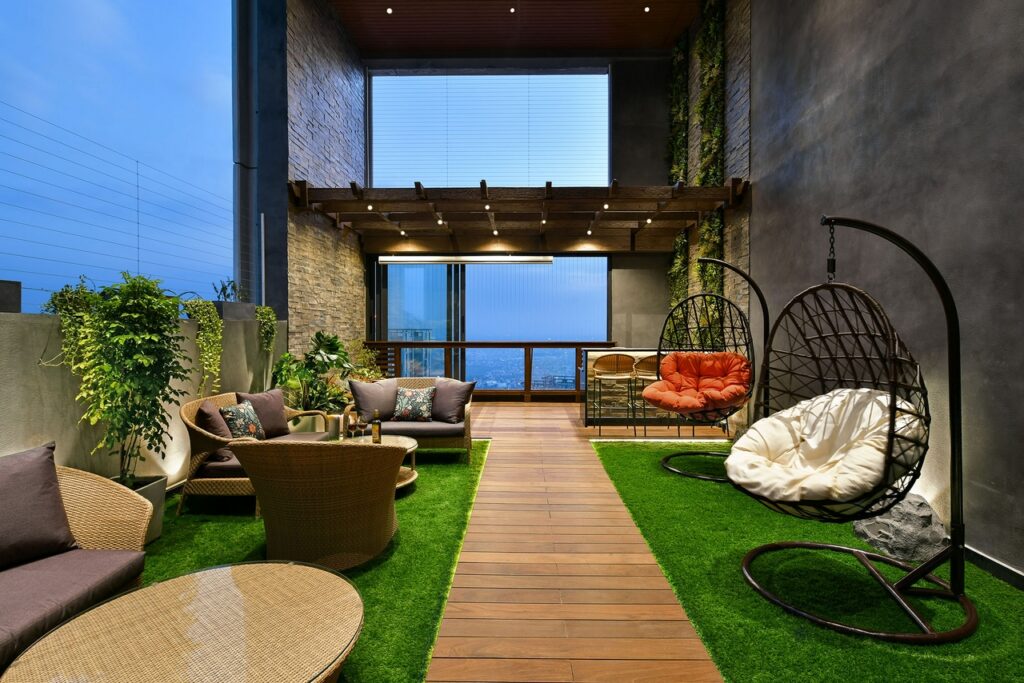 Outdoor area in luxurious home in Kolkata showing outdoor furniture and landscaping.