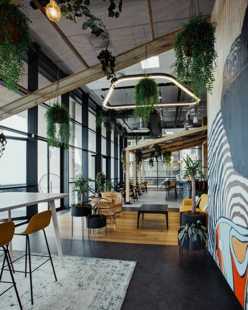 A modern open office space with a vibrant mural on the wall.