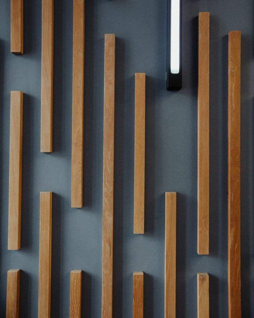 Vertical wooden slats with built-in lights on a dark wall.