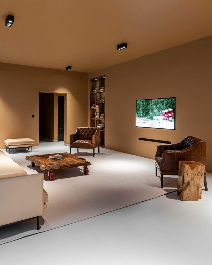 A minimalist living room with a minimalist tv area and vintage furniture, showcasing the charm of classic design. Also seen here are the live edge coffee table and tree stump side table.