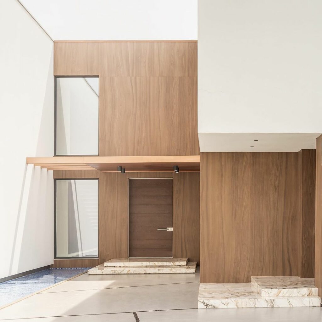 A modern home with wooden walls and a wooden entrance door.