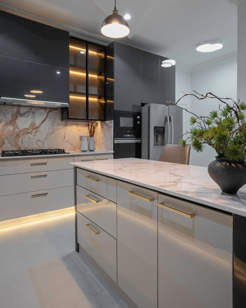 A contemporary kitchen featuring sleek marble countertops and a contrasting black island.