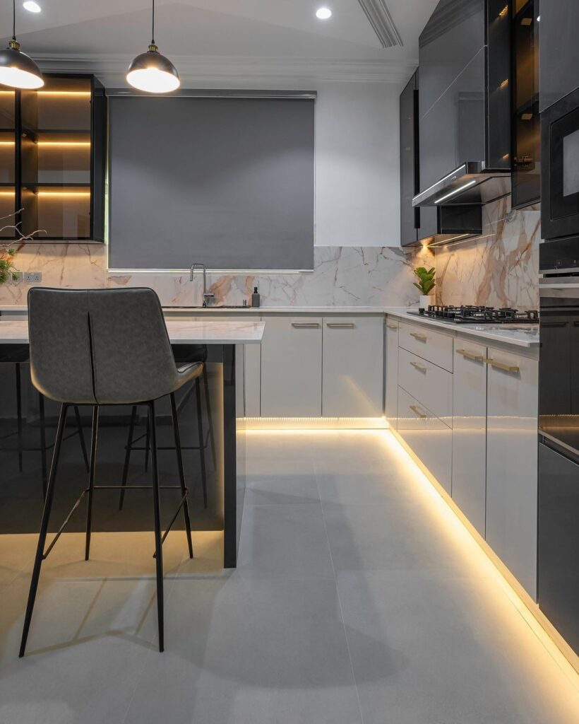 A contemporary kitchen featuring calcatta marble countertops and stylish lighting.