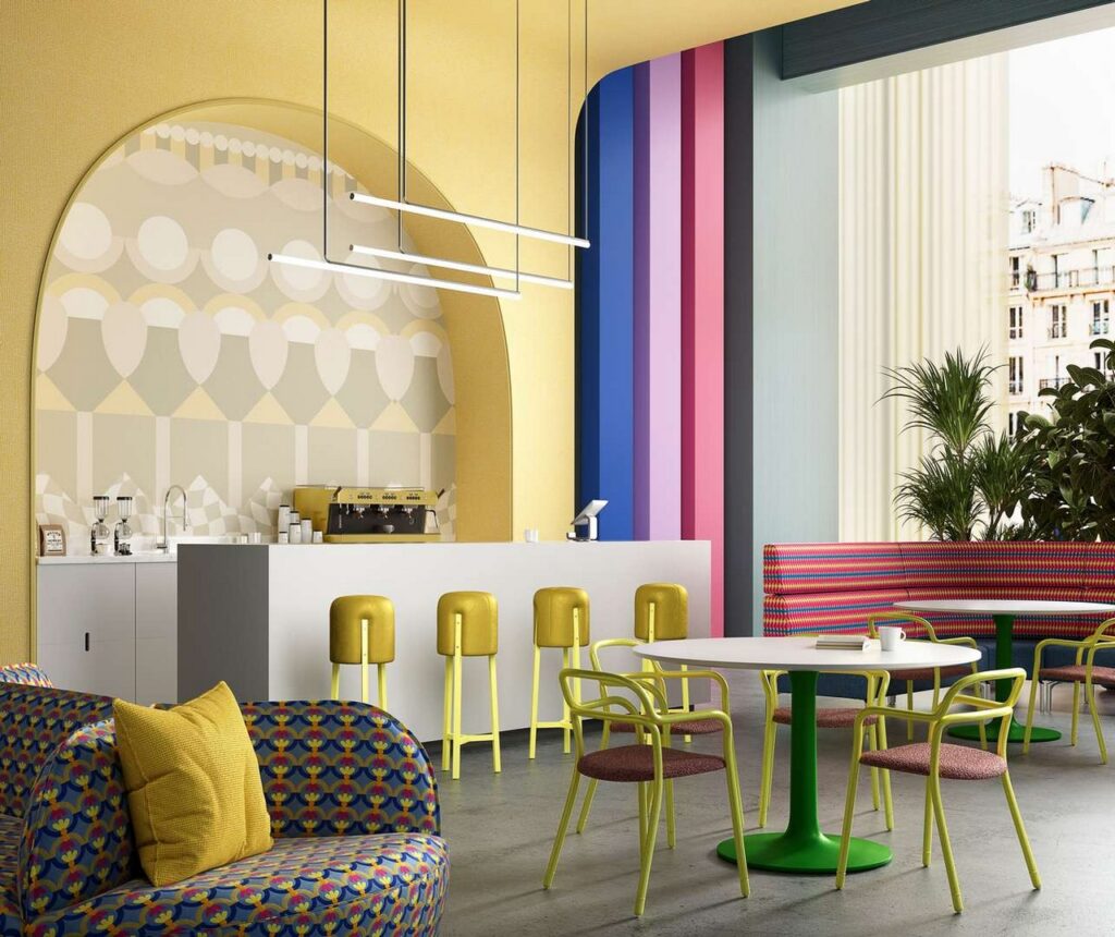 A vibrant cafe with a variety of colorful chairs and tables, creating a lively and inviting atmosphere.