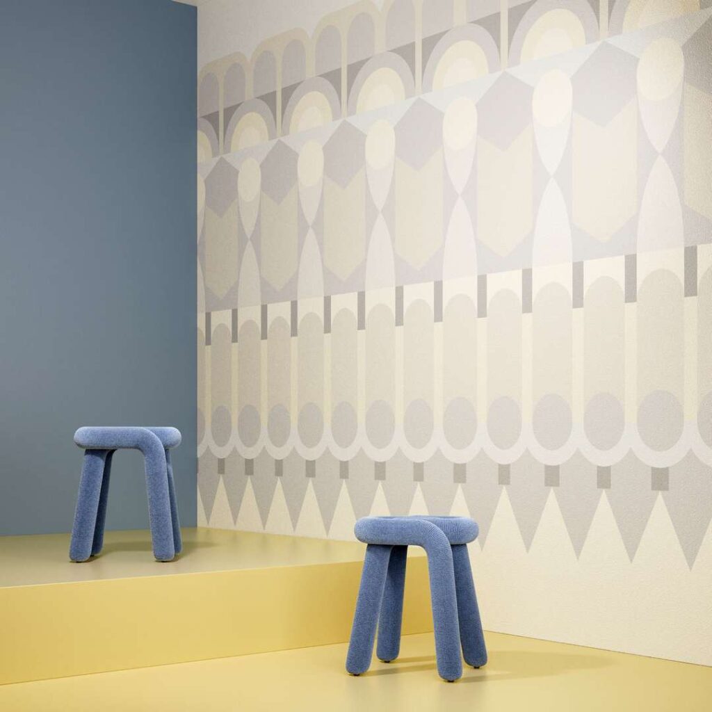 Two stools placed in front of a patterned wall.