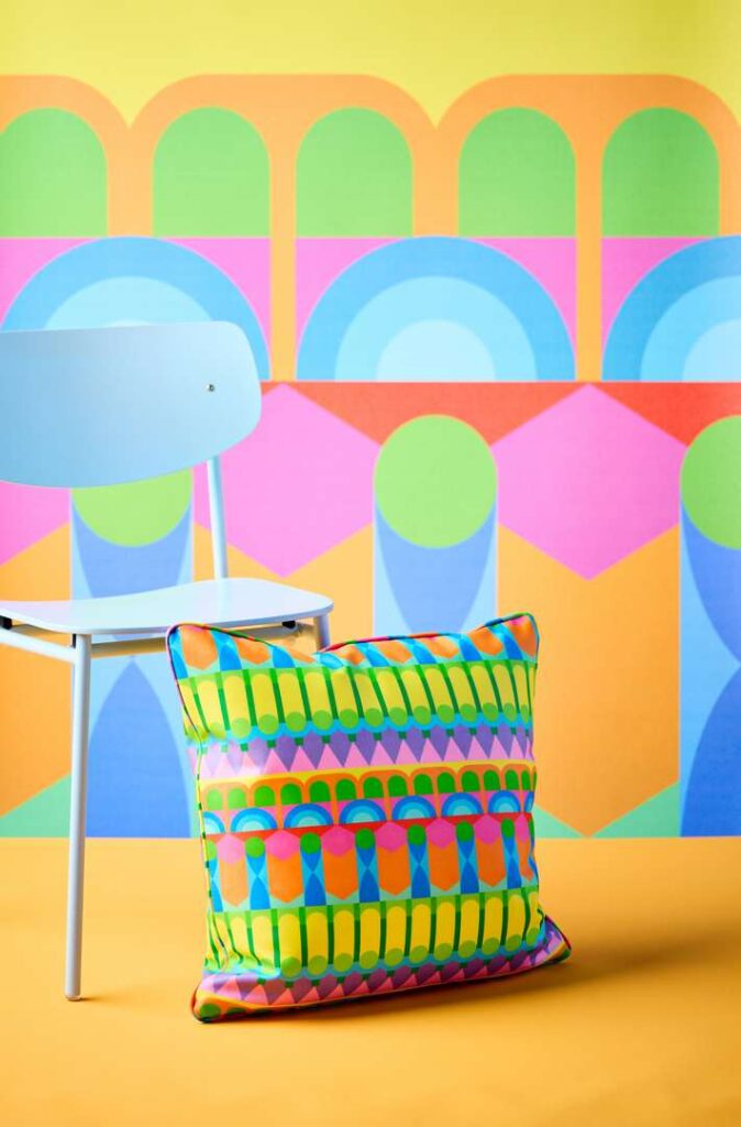 Colorful wall with chair and pillow, adding a pop of color to the room.