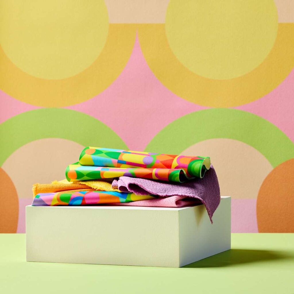 A vibrant box of colorful cloths placed on a lively wall.