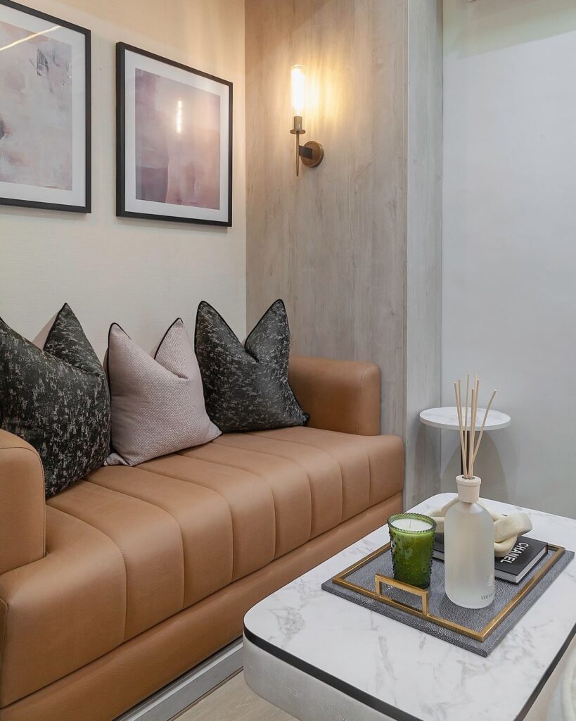A cozy compact lounge with a 2 seater sofa, coffee table, wall arts and contemporary wall light.