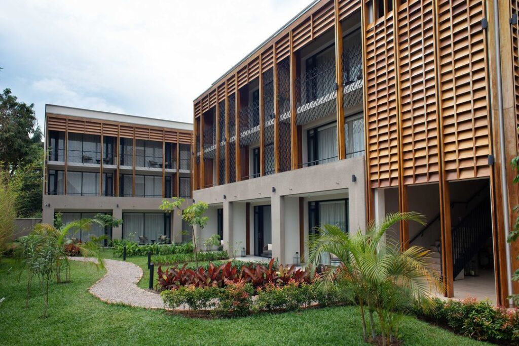 A contemporary building with wooden slats and lush green grass surrounding it.