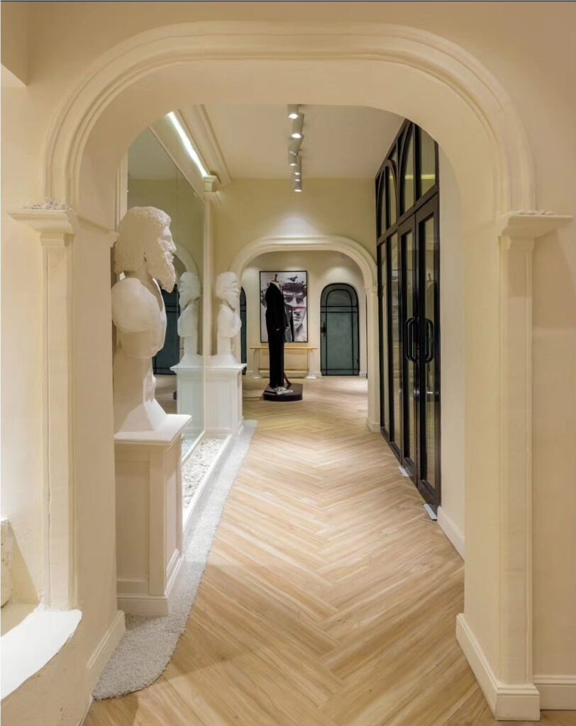 Arched hallway entry with classical mouldings and statues.