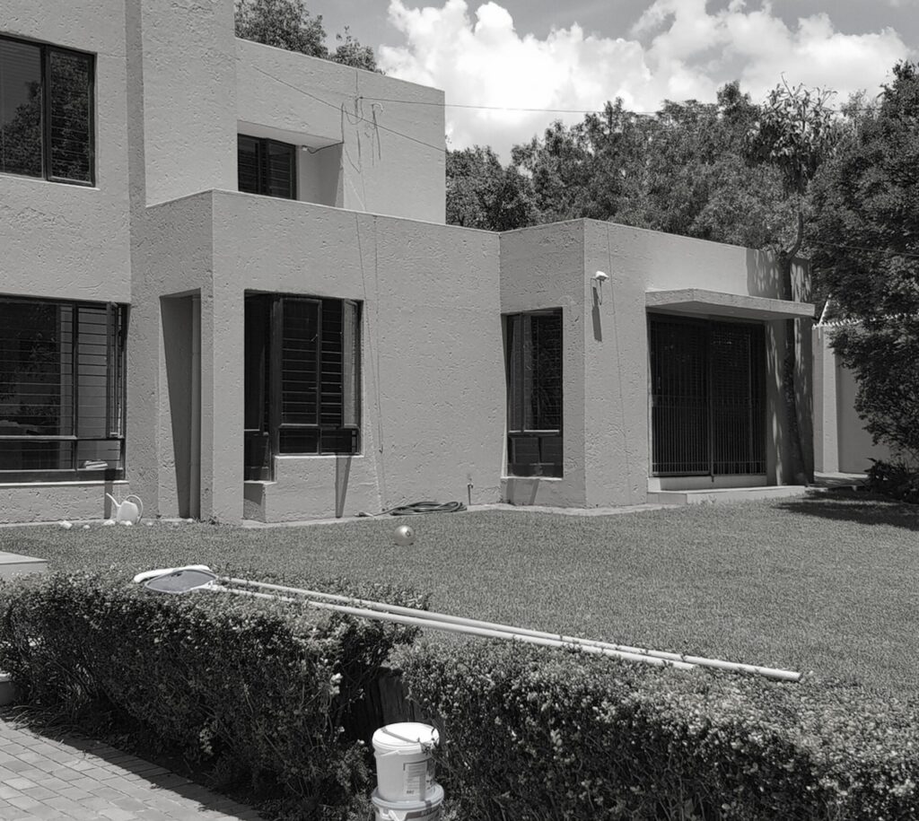 A black and white photo of a house with a neatly manicured lawn, creating a classic and timeless aesthetic.