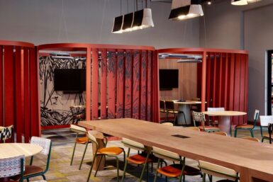 Conference room with red partitions and chairs, ideal for meetings and presentations.