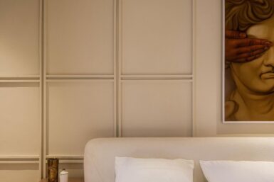 Muted colour bedroom with a panelled feature wall.