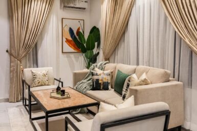 A cozy anteroom design featuring beige curtains and matching furniture, creating a warm and inviting atmosphere.